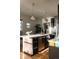Bright kitchen island with stainless steel appliances, pendant lighting, and hardwood floors at 3746 Jason St, Denver, CO 80211