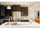 Modern kitchen with stainless steel appliances, a large island, and elegant pendant lighting at 3746 Jason St, Denver, CO 80211