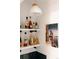 Stylish wet bar featuring open shelving, unique lighting, and a decorative photograph at 3746 Jason St, Denver, CO 80211