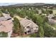 Aerial view of house nestled in wooded neighborhood near mountains and golf course at 3228 Country Club Pkwy, Castle Rock, CO 80108