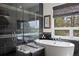Modern bathroom features a soaking tub and a glass-enclosed shower with tile surround at 3228 Country Club Pkwy, Castle Rock, CO 80108