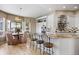 Open-concept kitchen with granite island, stainless hood, and dining nook featuring large bay windows at 3228 Country Club Pkwy, Castle Rock, CO 80108
