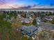 Breathtaking aerial view of a blue house nestled among lush greenery and a serene lake in the background at 3053 Mcintosh Dr, Longmont, CO 80503