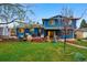 Charming blue two-story home with a lush backyard featuring a deck and mature trees at 3053 Mcintosh Dr, Longmont, CO 80503