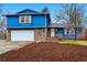 Charming two-story home with blue siding, brick accents, an attached garage, and a beautifully landscaped front yard at 3053 Mcintosh Dr, Longmont, CO 80503