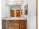 Double sink vanity in a bathroom featuring a large mirror, a tile countertop and a door leading to another room at 10047 Sylvestor Rd, Highlands Ranch, CO 80129
