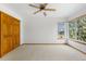 Bright bedroom with a ceiling fan, neutral carpet, wood trim, and large windows for natural light at 10047 Sylvestor Rd, Highlands Ranch, CO 80129