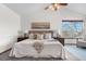Vaulted ceiling bedroom with a ceiling fan, large windows and a comfy bed with throw pillows at 10047 Sylvestor Rd, Highlands Ranch, CO 80129
