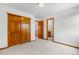 Bright bedroom features closet with paneled sliding doors and neutral carpeting at 10047 Sylvestor Rd, Highlands Ranch, CO 80129