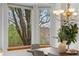 Bright dining room featuring a modern chandelier, wood table, and views of the surrounding trees at 10047 Sylvestor Rd, Highlands Ranch, CO 80129