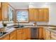 Charming kitchen with wood cabinets, granite countertops, and bright window overlooking the yard at 10047 Sylvestor Rd, Highlands Ranch, CO 80129