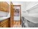 Well-equipped laundry room with modern washer/dryer, wooden cabinets, a sink and a painting with an abstract tree landscape at 10047 Sylvestor Rd, Highlands Ranch, CO 80129
