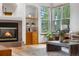 Living room with a cozy fireplace, built-in shelving, large windows, and comfortable seating at 10047 Sylvestor Rd, Highlands Ranch, CO 80129