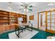 Bright office space featuring custom built-ins, stylish decor and a neutral area rug atop an emerald green carpet at 10047 Sylvestor Rd, Highlands Ranch, CO 80129