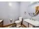 Powder room featuring modern fixtures, a pedestal sink, oval mirror and slate-style flooring at 1526 Peach Ct, Brighton, CO 80601