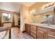 Charming bathroom boasting wood cabinets, tile floors, granite counters, a jacuzzi tub and a separate shower at 1526 Peach Ct, Brighton, CO 80601