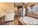 Beautiful bathroom with a jacuzzi tub, a glass enclosed shower and access to an open walk-in closet at 1526 Peach Ct, Brighton, CO 80601
