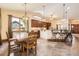 Kitchen with island that has seating, next to a wood table and chairs, lots of light, and hardwood floors at 1526 Peach Ct, Brighton, CO 80601