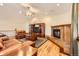 Open-concept living room with a fireplace, hardwood floors, and a comfortable leather sofa at 1526 Peach Ct, Brighton, CO 80601