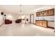 Open floor plan featuring bar, living room, neutral walls, and tiled floors at 1526 Peach Ct, Brighton, CO 80601