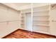 Large walk-in closet featuring extensive shelving and hardwood floors, providing ample storage space at 1526 Peach Ct, Brighton, CO 80601