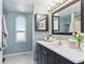 The powder blue bathroom features a new vanity and fixtures and a large arching window at 5027 E Barrington Ave, Castle Rock, CO 80104