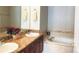 Relaxing bathroom features dual sinks, vanity, granite counters, and a luxurious soaking tub at 11328 W Radcliffe Dr, Littleton, CO 80127