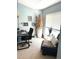 Bright home office with a modern black desk, chair and a cozy reading corner near the window at 11328 W Radcliffe Dr, Littleton, CO 80127