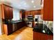 Modern kitchen with rich wood cabinetry, granite countertops, stainless steel appliances, and hardwood flooring at 11328 W Radcliffe Dr, Littleton, CO 80127