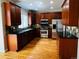 Modern kitchen featuring wood cabinets, stainless steel appliances, and dark countertops at 11328 W Radcliffe Dr, Littleton, CO 80127