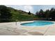 Inviting community pool surrounded by a concrete deck, adjacent to grassy hillside at 11328 W Radcliffe Dr, Littleton, CO 80127