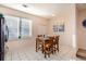 Well-lit dining area features a wooden table with four chairs, complemented by neutral walls and a large window at 2769 W Riverwalk Cir # E, Littleton, CO 80123