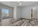 Bright bedroom with gray-toned wood floors, ceiling fan and sliding glass doors to a balcony at 8330 Zuni St # 219, Denver, CO 80221