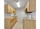 Kitchen featuring light wood cabinetry, essential appliances, and tile floor at 8330 Zuni St # 219, Denver, CO 80221