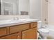 Bathroom featuring a wooden vanity, tile countertop, white toilet, and a bathtub with tiled walls at 9318 Las Ramblas Ct # R, Parker, CO 80134