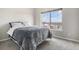 Bright bedroom featuring a plush bed, carpet floors, and a large window with neighborhood views at 9318 Las Ramblas Ct # R, Parker, CO 80134