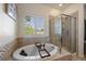 Bright bathroom highlighting a soaking tub with jets, walk-in shower, and shuttered window at 5437 S Granby Ct, Aurora, CO 80015
