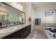 Bathroom featuring dual sinks, soaking tub, walk-in shower, and updated fixtures at 5437 S Granby Ct, Aurora, CO 80015