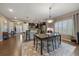 Dining area with a view of the modern kitchen with stainless appliances and stylish lighting, flowing design to front door at 5437 S Granby Ct, Aurora, CO 80015