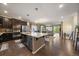 Open-concept kitchen flowing into the living area, with stainless steel appliances, dark cabinets, and a center island at 5437 S Granby Ct, Aurora, CO 80015
