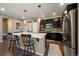 Spacious kitchen featuring an island with seating, modern stainless steel appliances, and dark wood cabinetry at 5437 S Granby Ct, Aurora, CO 80015