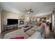 Open-concept living room with fireplace, ceiling fan, and view into kitchen and dining area at 5437 S Granby Ct, Aurora, CO 80015