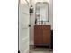 Modern bathroom vanity featuring black faucet, mirror, and wood-grain cabinet at 4590 Grove St, Denver, CO 80211