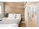 Bedroom with wood accent wall, stylish decor, and view into hallway at 4590 Grove St, Denver, CO 80211