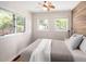 Bedroom featuring wood accent wall, ceiling fan and two windows providing natural light at 4590 Grove St, Denver, CO 80211