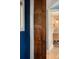 Dark wood bedroom door with a view into a bathroom with light fixtures, and a wooden vanity at 4590 Grove St, Denver, CO 80211