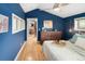 Bright bedroom with a doorway view to a bathroom, wood floors, and blue accent wall at 4590 Grove St, Denver, CO 80211