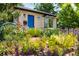 Attractive home exterior with a bright blue front door and beautiful landscaping with colorful flowers at 4590 Grove St, Denver, CO 80211