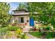 Charming home featuring a blue front door, manicured landscaping, and a welcoming front porch at 4590 Grove St, Denver, CO 80211