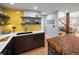 Modern kitchen with contrasting yellow backsplash and wood accents, connecting to an open living area at 4590 Grove St, Denver, CO 80211
